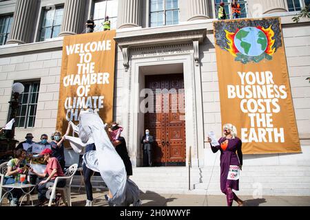 Washington, United States. 14th Oct, 2021. Signs hang in front of a building during the demonstration. Extinction Rebellion protesters took over the front of the Chamber of Commerce to call on the Biden administration to tackle the climate change crisis. (Photo by Karla Cote/SOPA Images/Sipa USA) Credit: Sipa USA/Alamy Live News Stock Photo