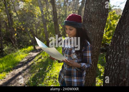 Happy biracial woman taking break from hiking in countryside Stock Photo