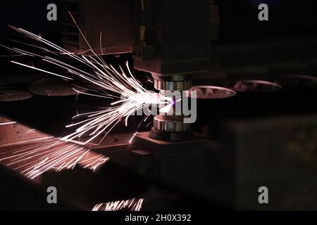 Industrial Laser cutting processing manufacture technology of flat sheet metal steel material with sparks Stock Photo