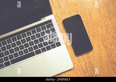 Modern laptop and smartphone on wooden table with top view Stock Photo