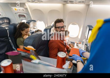 Happy man in glasses waiting for lunch box on board the aircraft Stock Photo