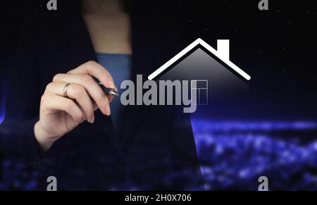 Smart Home concept, technology of home automation system. Hand holding digital graphic pen and drawing digital hologram Smart Home sign on city dark b Stock Photo