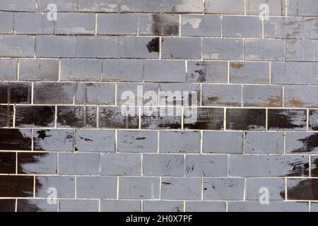 wall with old black glossy tiles. High quality photo Stock Photo