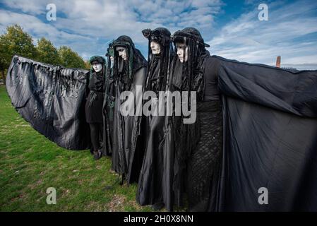 Extinction Rebellion's silent 'Black-Rebels' pose in silence during the demonstration.On the fourth-day of climate activities, Extinction Rebellion protesters held a silent march to commemorate the victims of the climate crisis. One-hundred and fifty Extinction Rebellion rebels mostly dressed in black, walked in silence through the streets of The Hague on a four-kilometer march. They carried placards emphasizing the victims of extreme weather during the past year. Leading the silent protest were the 'Black-Rebels', they escorted the funeral procession from the Malieveld, the short distance to Stock Photo