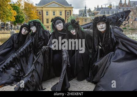 Extinction Rebellion's silent 'Black-Rebels' pose in silence during the demonstration.On the fourth-day of climate activities, Extinction Rebellion protesters held a silent march to commemorate the victims of the climate crisis. One-hundred and fifty Extinction Rebellion rebels mostly dressed in black, walked in silence through the streets of The Hague on a four-kilometer march. They carried placards emphasizing the victims of extreme weather during the past year. Leading the silent protest were the 'Black-Rebels', they escorted the funeral procession from the Malieveld, the short distance to Stock Photo