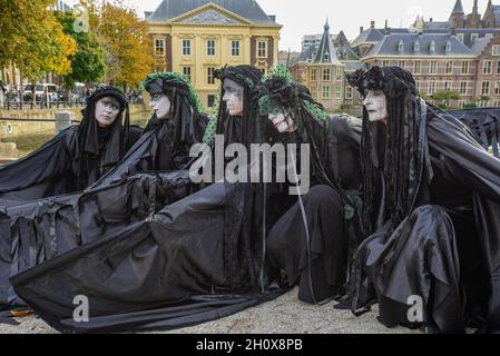 Extinction Rebellion's silent 'Black-Rebels' pose in silence during the demonstration.On the fourth-day of climate activities, Extinction Rebellion protesters held a silent march to commemorate the victims of the climate crisis. One-hundred and fifty Extinction Rebellion rebels mostly dressed in black, walked in silence through the streets of The Hague on a four-kilometer march. They carried placards emphasizing the victims of extreme weather during the past year. Leading the silent protest were the 'Black-Rebels', they escorted the funeral procession from the Malieveld, the short distance to Stock Photo