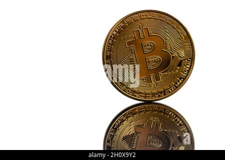 Closeup golden bitcoin with reflection isolated on white background. Bitcoin is reflected in the mirror. Stock Photo
