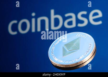 Coinbase, is an American company that operates a cryptocurrency exchange platform. Ethereum coin on the background of the coinbase inscription. Stock Photo