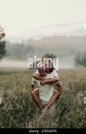 Man giving girlfriend piggyback ride Stock Photo