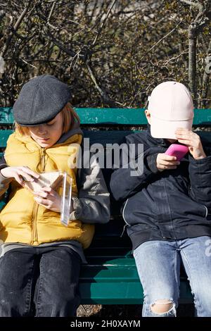 Children sitting on bench Stock Photo