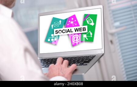 Social web concept shown on a laptop used by a man Stock Photo
