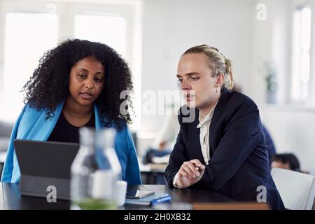 Female coworkers talking in office Stock Photo