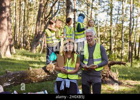 Smiling teachers looking at camera, children in background Stock Photo