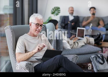 Man in modern office using digital tablet Stock Photo