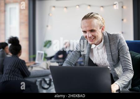Man in modern office using laptop Stock Photo