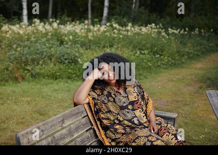 Young beautiful woman sitting on bench Stock Photo