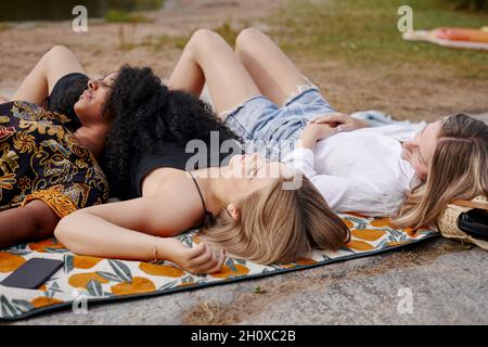 Three friends lying on blanket Stock Photo