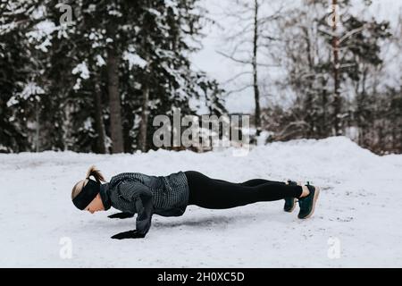Woman doing push-ups at winter Stock Photo