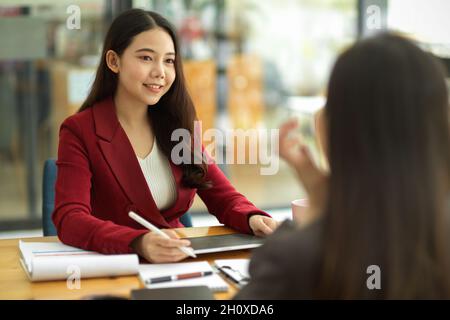 Asian business women interviewing female candidate at job interview. human resource. Business partners consulting about business benefit in office Stock Photo