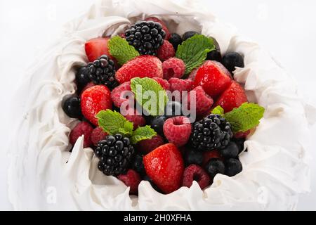 Delicious Pavlova cake with meringue topped and fresh berries isolated on white background Stock Photo