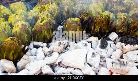 Artichokes being cooked on charcoals Stock Photo