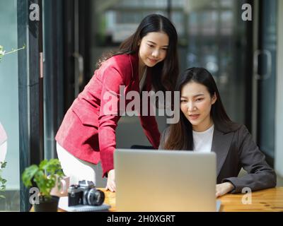 Two of beautiful businesswomen having webinar online conference meeting with business workers and partners. Online conference meeting and long-distanc Stock Photo