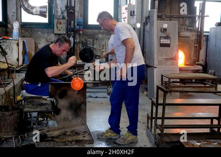 Inside Venini famous glass Factory during the Glass art Conference in Murano. Master glass blower during hot glass working in Venice, Italy, July 03, Stock Photo