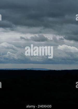 Dark, atmospheric, low-key hilltop skyline, with the silhouettes of Surrey’s hills under a heavy, dramatic cloudscape. Stock Photo
