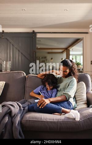 Mother and son using tablet on sofa Stock Photo
