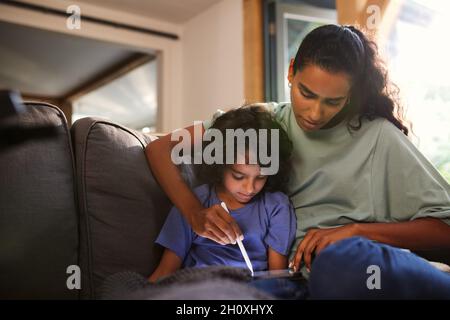 Mother and son using tablet on sofa Stock Photo
