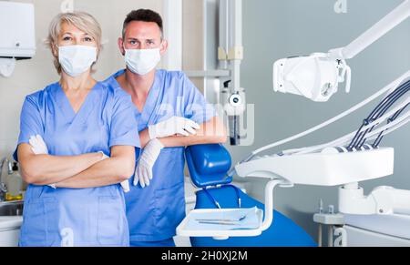 Portrait of two dentists wearing medical masks standing in medical office Stock Photo