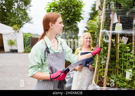 Gardener team with checklist when checking flower delivery in garden center Stock Photo