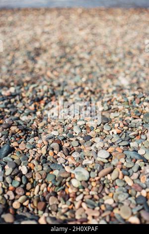 Selective focus on smooth sea rocks on the beach - small beach pebbles Stock Photo