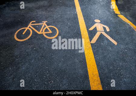 Bicycle and pedestrian yellow sign on black asphalt Stock Photo