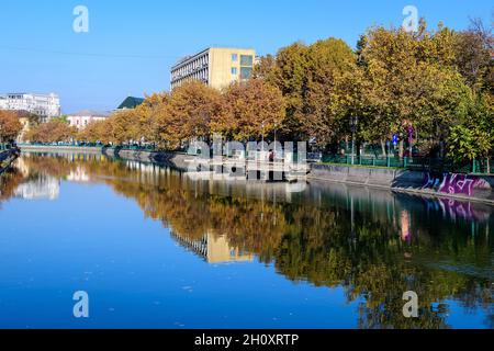 Bucharest, Romania, 22 November 2020 - Dambovita river, old buildings and yellow, orange and brown leaves in large trees in the center of Bucharest, R Stock Photo