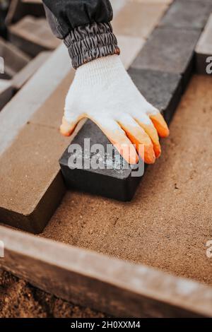 Laying paving slabs of different shades on a sand cushion - combining paving stones Stock Photo
