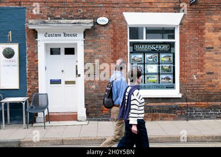 Couple people looking in Estate Agent window at houses for sale rent housing market property in Rye East Sussex England Great Britain UK KATHY DEWITT Stock Photo