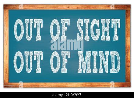 OUT OF SIGHT OUT OF MIND written on blue wooden frame school blackboard Stock Photo