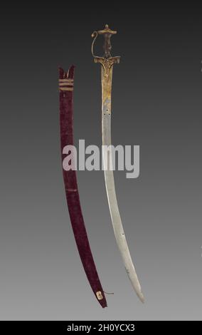 Tulwar sword, 1700s. India, probably Deccan. Iron hilt with gold; steel blade with gold; wood scabbard with velvet and metallic thread; overall: 96.6 cm (38 1/16 in.).  This long curved sword and scabbard are of the kind used and worn by Mughal nobility, as seen often in paintings. The openwork hilt is a characteristic of swords from the southern Indian region known as the Deccan. By the end of the 1500s, the Mughals began making regular incursions into the Deccan as they attempted to expand their empire, increasing the exchange of art forms. Repeated four times, twice on one side of the blade Stock Photo