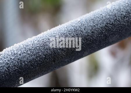 Hoarfrost on top a silver metal pipe. Frosted pipe was photographed in Finland during an ice cold and freezing day. Closeup color image. Stock Photo