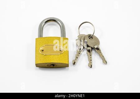Yellow steely lock and bunch of keys isolated on white background Stock Photo