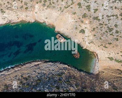 aerial drone view of Shipwreck Olympia boat in Amorgos island during summer holidays, at the coastal rocky area, people on the beach, Cyclades, Greece Stock Photo