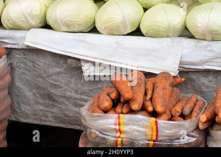 Carrots in bags, white cabbage in the background at the farmer's market Stock Photo