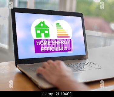 Man using a laptop with home energy efficiency concept on the screen Stock Photo