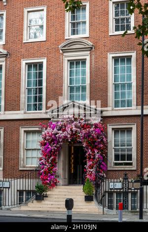 Plastic flowers decorating an entrance to a building on Grosvenor Square, Mayfair, City of Westminster, London, England, UK Stock Photo