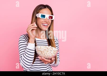 Photo of excited shiny young woman dressed striped pullover 3d eyewear eating pop corn empty space isolated pink color background Stock Photo