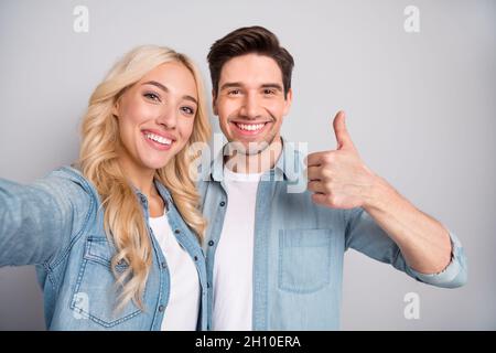 Photo of young cheerful couple happy positive smile make selfie show thumb-up like cool isolated over grey color background Stock Photo