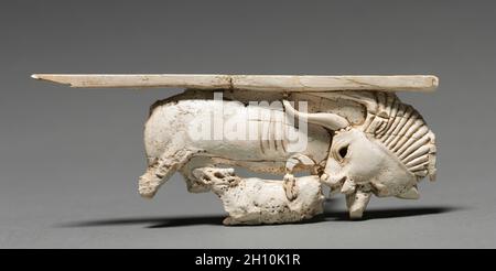 Decorative Plaque: Cow Nursing Its Calf, 900-800 BC. Phoenician, Iraq, Nimrud, 9th-8th Century BC. Ivory; overall: 4.6 x 12.4 cm (1 13/16 x 4 7/8 in.). Stock Photo