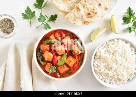 Thai style red chicken curry with vegetables in bowl over light background. Top view, flat lay Stock Photo
