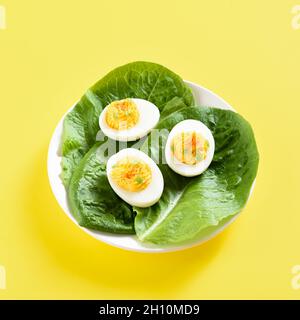 Close up view of deviled eggs with paprika, mustard and mayonnaise on yellow background. Stock Photo